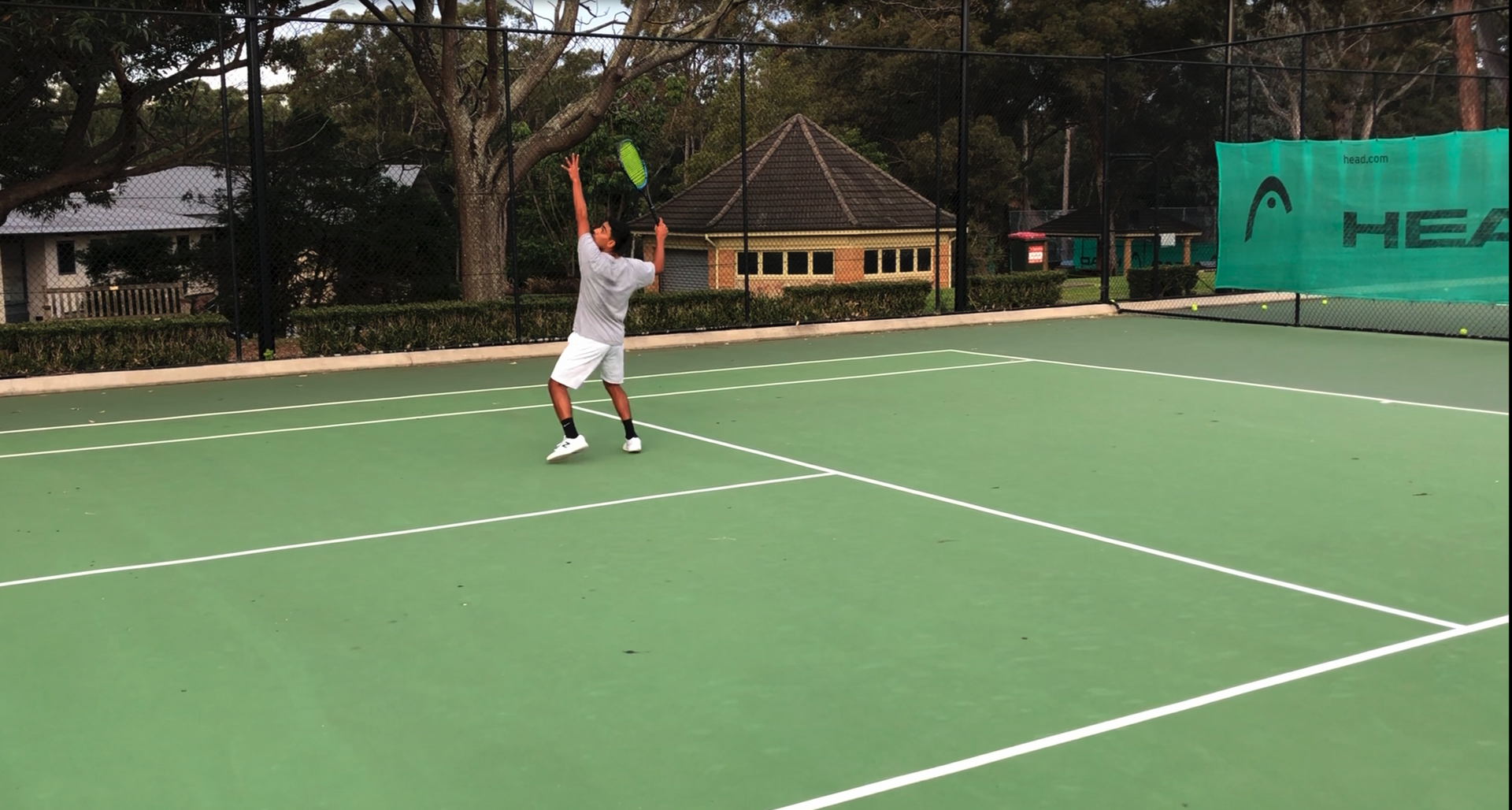 Serving in whites on a tennis court
